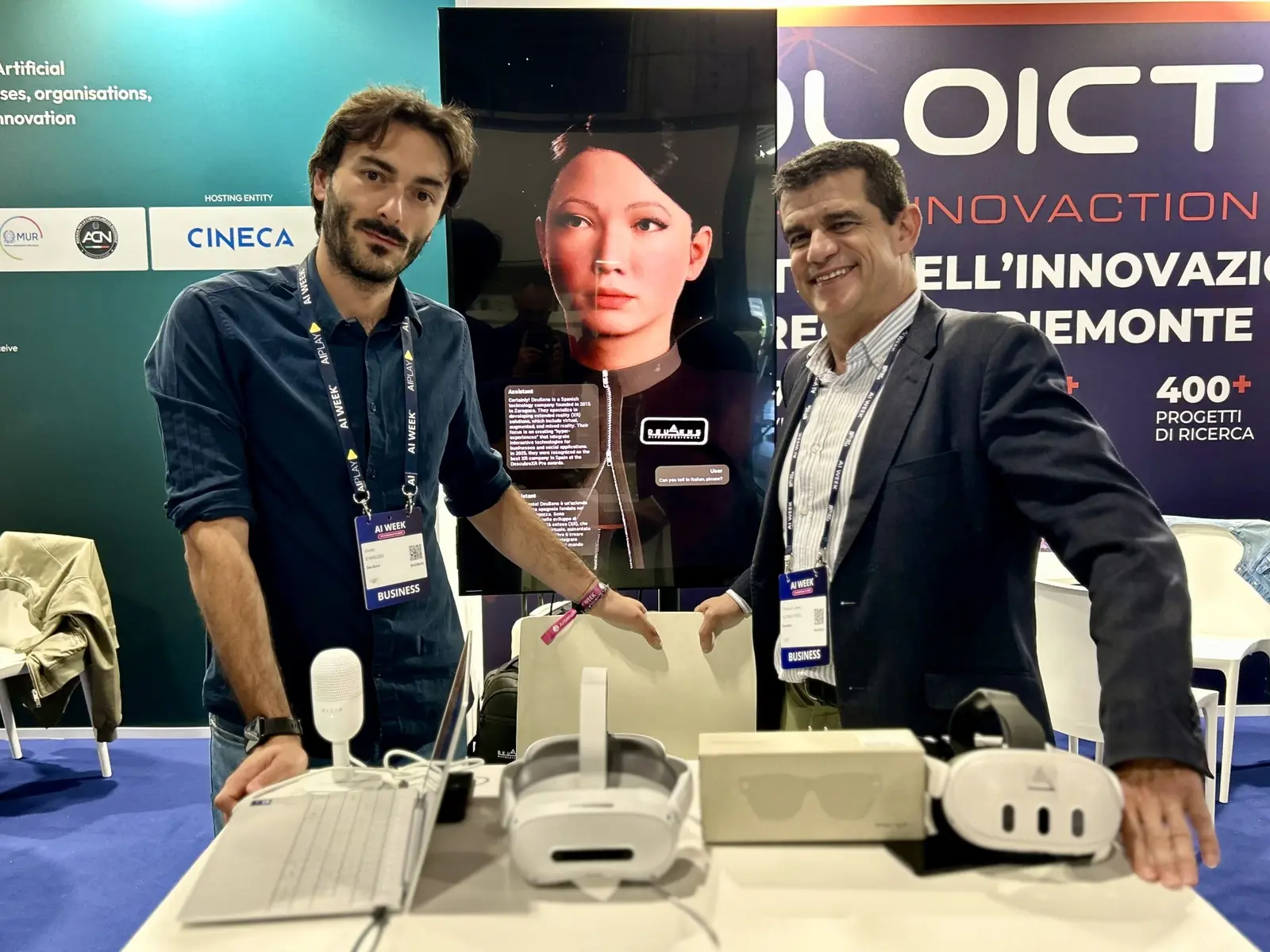 Guido D'Arezzo y Francisco Javier Alonso Peña en el stand de DeuSens en AI Week 2026 con el avatar Alice Assistant y visores de realidad virtual